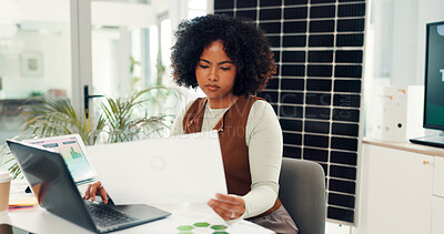Buy stock photo Black woman, paperwork and typing on laptop in office for results, energy saving stats and sustainable. Person, pc and document on photovoltaic grid revenue, company performance and solar panel sales