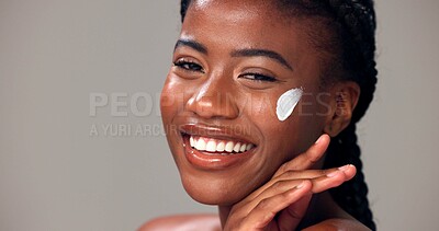 Buy stock photo Beauty, woman and happy with face cream in studio for healthy skin, hydration and hyaluronic acid. Portrait, black person and smile on gray background for skincare treatment results and natural glow