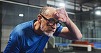Padel, tired and mature man with sweat for game, match and training for challenge. Indoor court, sports and person breathe with fatigue, rest and break for workout, exercise and fitness for tennis