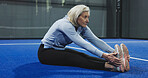 Fitness, padel or mature woman stretching on court for game preparation, start practice or workout. Turf, person and legs warm up at indoor tennis club for sport performance, flexibility and agility