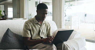 Buy stock photo Laptop, remote work and typing with black man on sofa in living room of home for small business. Computer, planning and report with freelance African employee in apartment for startup research