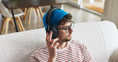 Buy stock photo Headphones, relax and man on couch in home with music, playlist or radio on weekend. Thinking, audio technology and male person streaming album, podcast or song online in living room at apartment