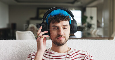 Buy stock photo Headphones, relax and man on sofa in home with music, playlist or radio on weekend. Thinking, audio technology and male person streaming album, podcast or song online in living room at apartment