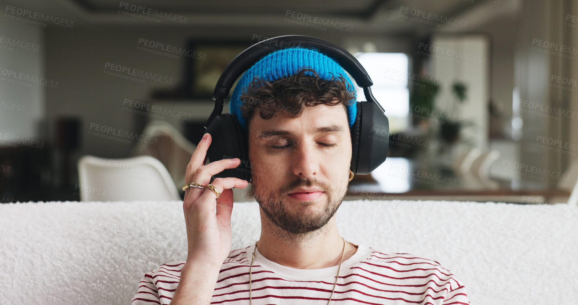 Buy stock photo Headphones, relax and man on sofa in home with music, playlist or radio on weekend. Thinking, audio technology and male person streaming album, podcast or song online in living room at apartment