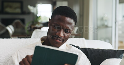 Buy stock photo Freelancer, tablet and research with black man on sofa for editor feedback, blog writer or reading. Online review, report and remote worker or person in living room of home for newsletter schedule