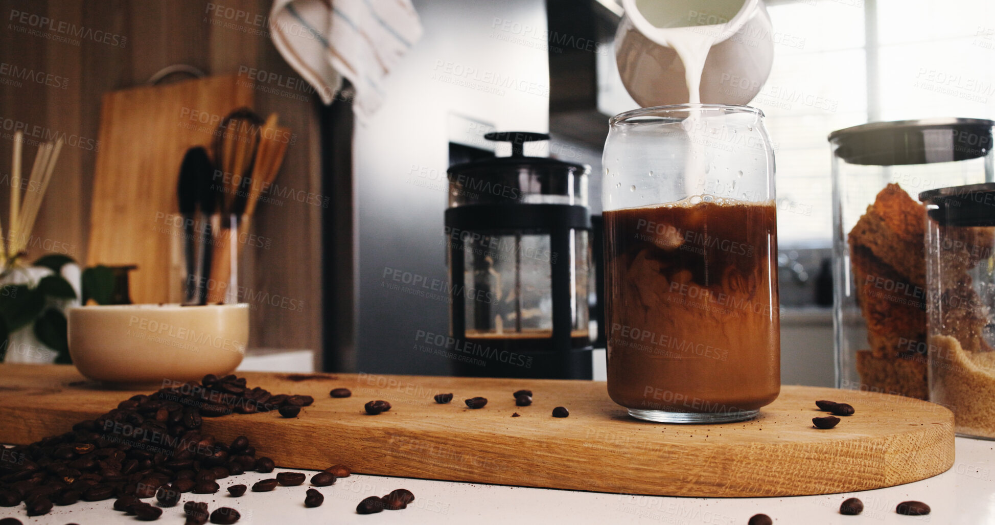 Buy stock photo Pouring, cream and ice coffee preparation in kitchen, beans and ingredients for caffeine and liquid. Making, cold beverage and drink with antioxidants in glass, mixing and process with milk in house