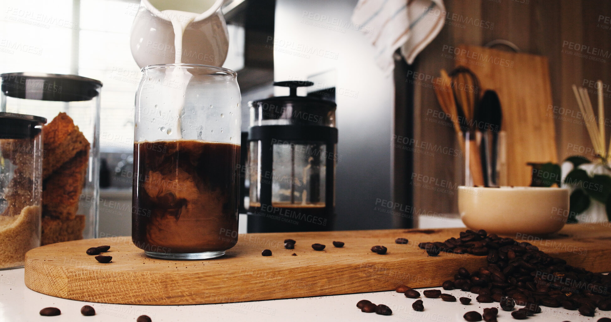 Buy stock photo Pouring, cream and ice coffee in kitchen, beans and ingredients for caffeine beverage, milk or latte. Breakfast, cold brew and liquid with antioxidants in glass, grain and process for drink in house