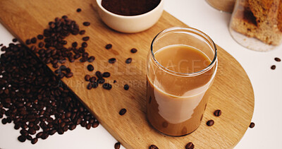 Buy stock photo Coffee, glass and beans in kitchen for strong caffeine, pour or roast in home. Organic brew, drink and blend with cappuccino for mocha, espresso or breakfast beverage in house for morning preparation