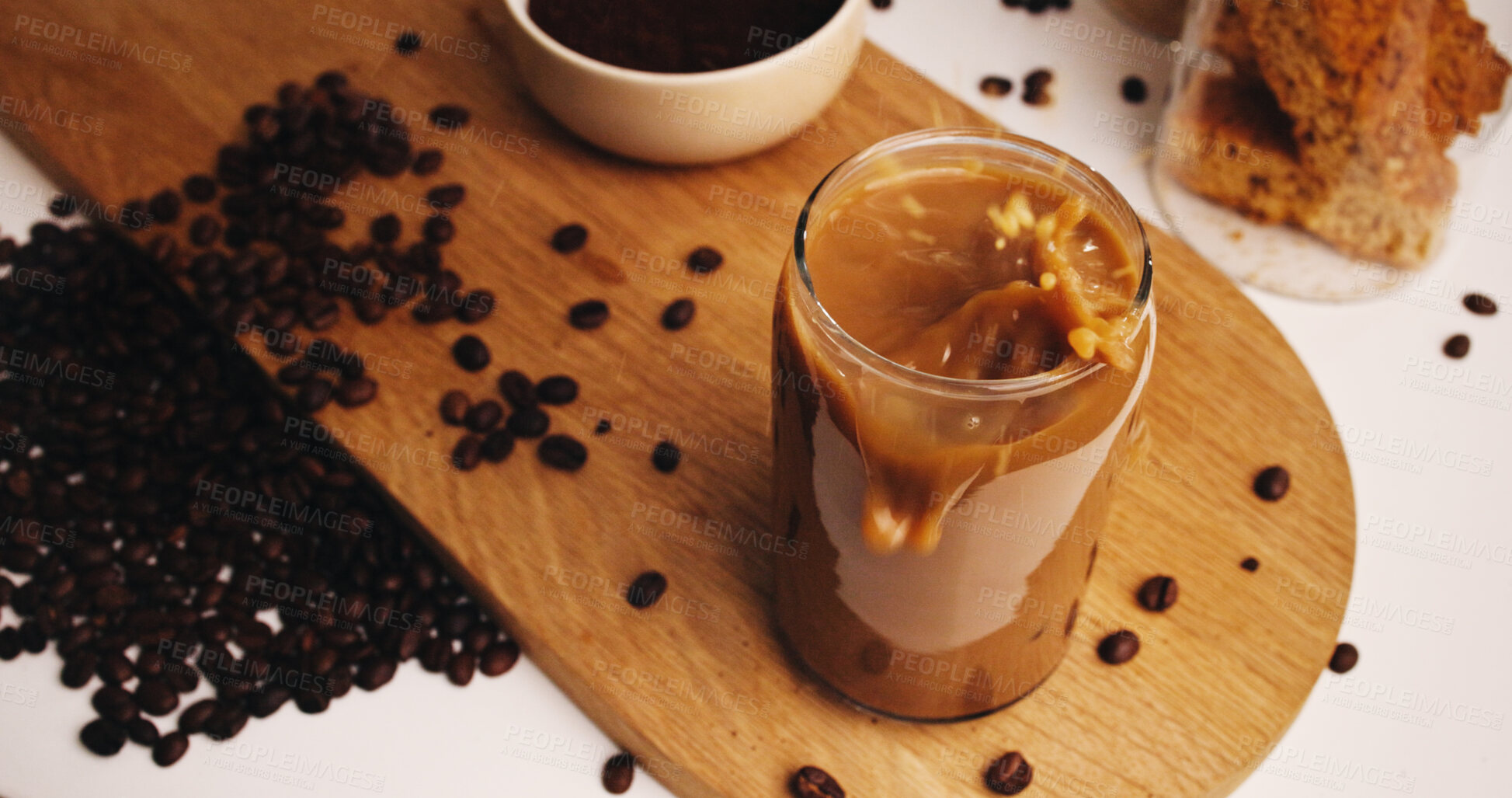 Buy stock photo Splash, coffee and glass on table in kitchen of home for caffeine beverage, breakfast and morning brew. Cappuccino, iced latte drink and prepare with above of cup in apartment for liquid and beans