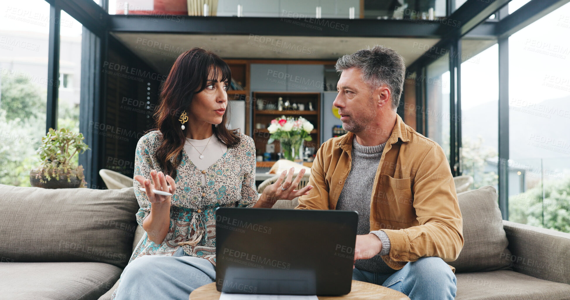 Buy stock photo Couple, talking and sofa with laptop in home for planning, review budget and online payment. Mature people, discussion and pc for household expenses, financial savings and loan application on funding