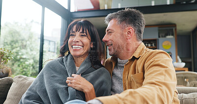 Buy stock photo Love, couple and relax with laughing on sofa for cozy weekend, funny conversation or connection. Happy, mature people and comfortable with blanket in home for holiday break, bonding together and joke