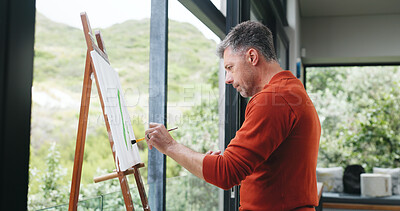 Buy stock photo Mature, man and painting canvas with easel for art, drawing or creative sketching in home. Male person, artistic or landscape painter with brush, frame or artwork for craft, skill or talent in house