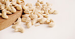 Space, nuts and cashews on table for diet, vegan meal and healthy snack for nutrition. White background, production and roasted seeds on wooden board for organic food, natural vitamins and protein