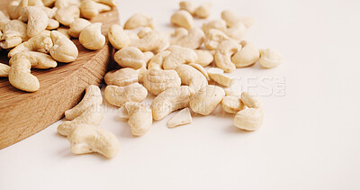 Buy stock photo Space, nuts and cashews on table for diet or vegan snack for health, wellness and nutrition. White background, vitamins and roasted seeds on wooden board for organic food, natural fats and protein