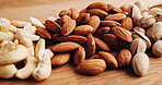 Closeup, kitchen and nuts on counter for diet, vegan meal and healthy snack for nutrition. Table, seed production and roasted pistachios, almonds and cashews for organic food, natural fats or protein
