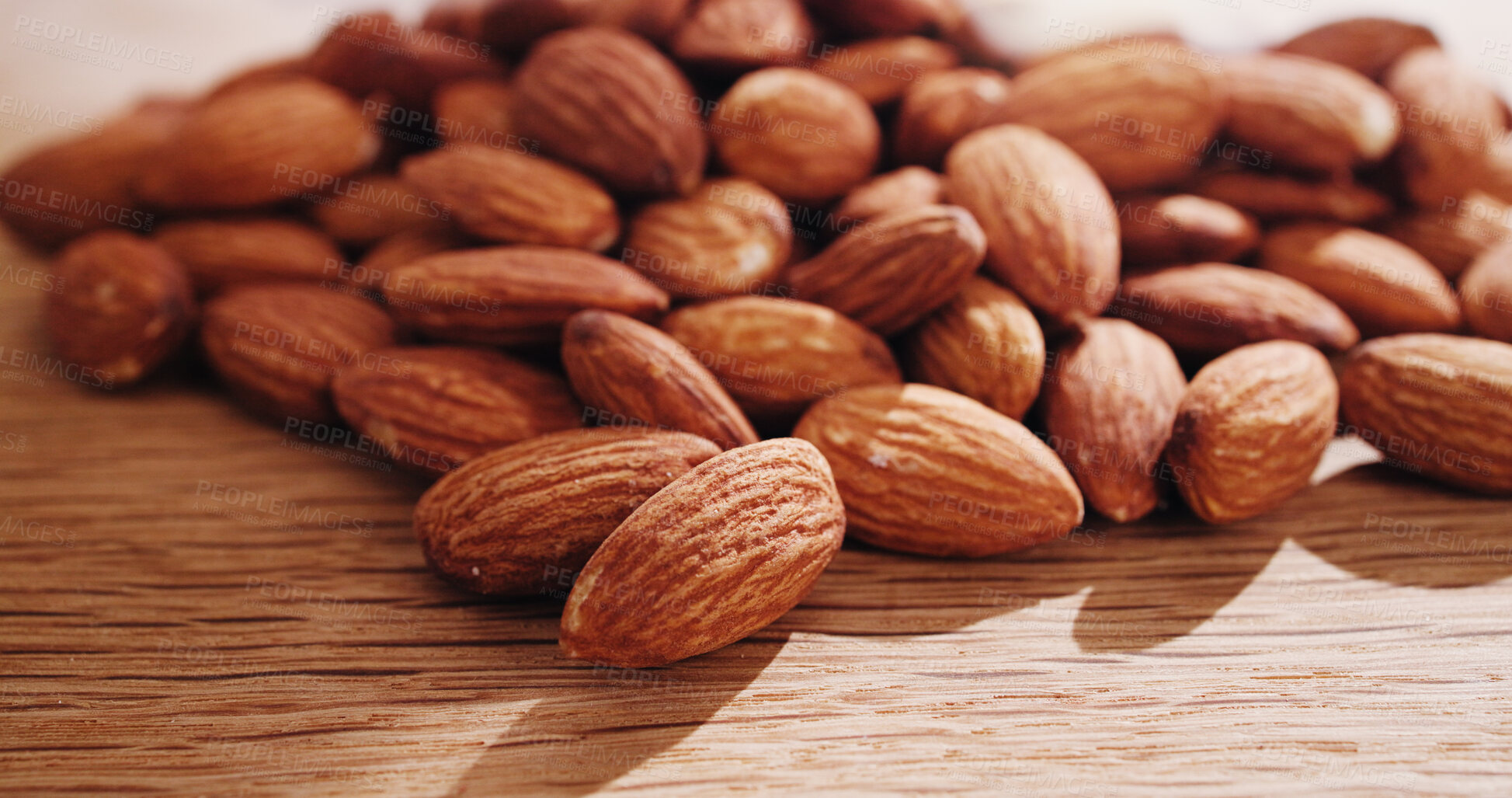 Buy stock photo Space, nuts and almonds on table for diet, vegan meal and healthy snack for nutrition. Background, food production and roasted seeds on wooden board for organic benefits, natural vitamins and protein