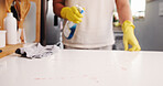 Spring cleaning, hands and glove at kitchen counter with disinfectant, housework or sanitation of surface. Space, chores or person in house with detergent, bacteria or germ removal in liquid spray.