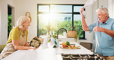 Buy stock photo Laughing, flowers and cooking with old couple in kitchen of home for anniversary celebration, romance and gift. Love, present and bouquet with senior man and woman for joke, playful and meal prep