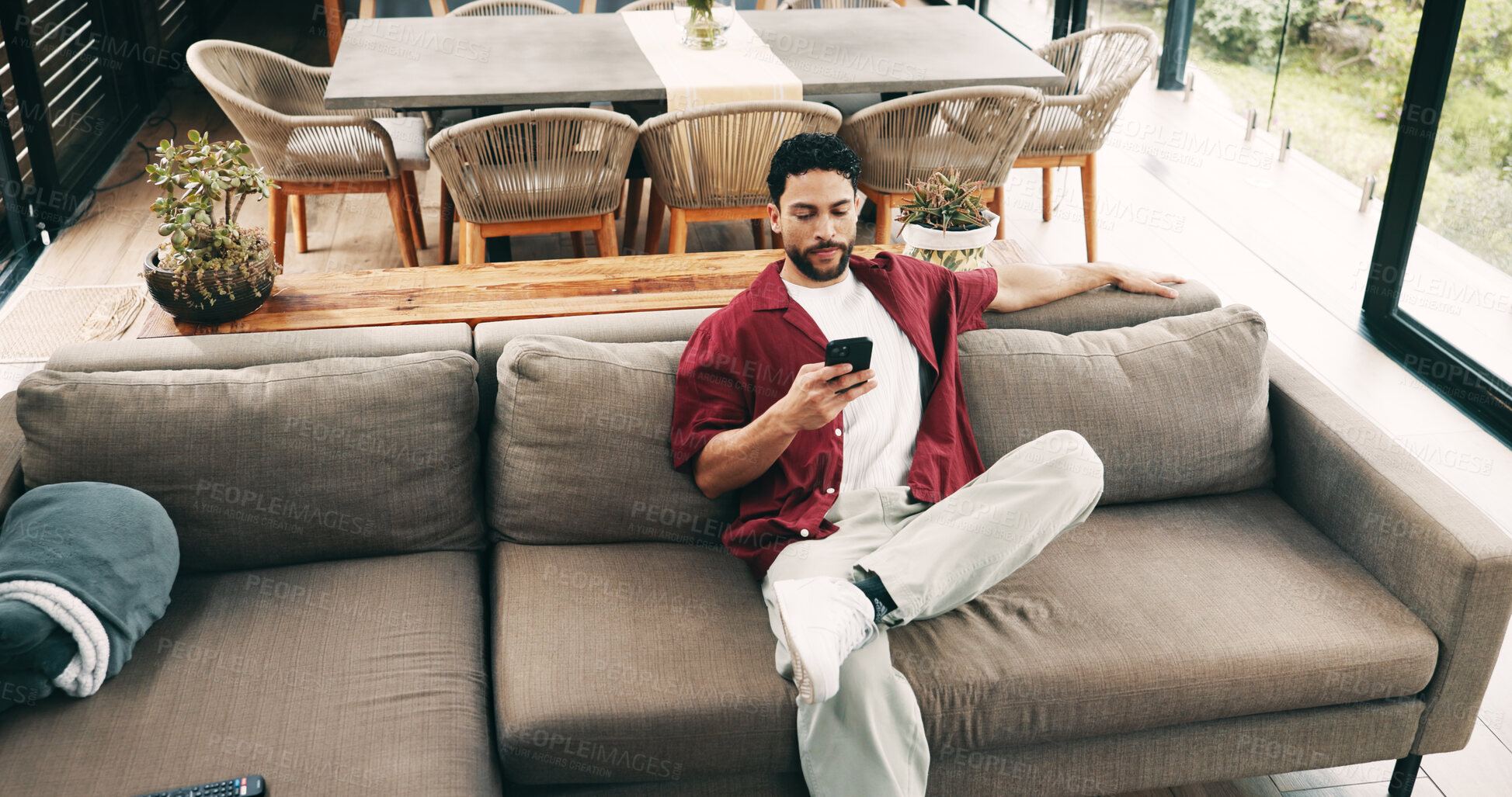 Buy stock photo Above, man and relax with phone at house for social media, browsing website and texting contact. Male person, rest or mobile to download game, online notification and chat with message update on sofa