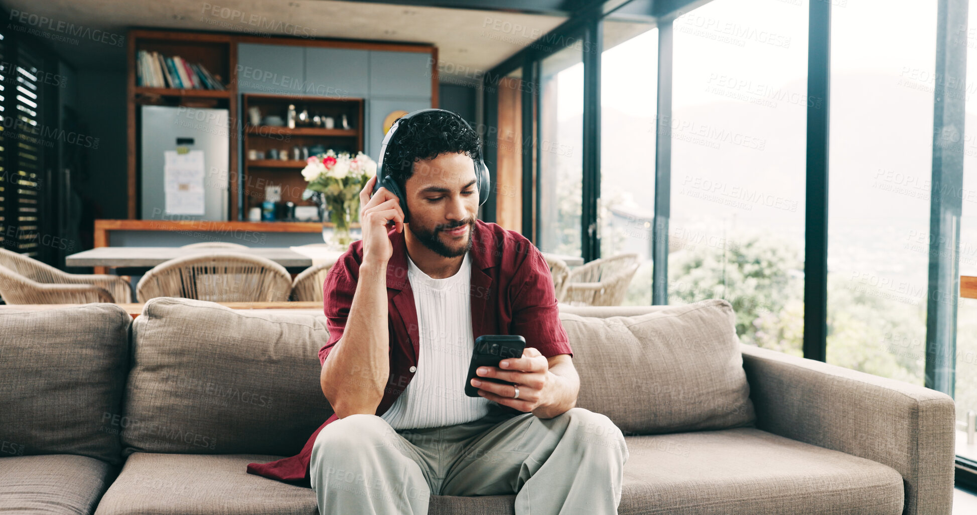 Buy stock photo Happy man, headphones or listening with phone on sofa for audio streaming or music in home. Male person, user or smile with mobile smartphone or app for sound playlist, tune or entertainment in house
