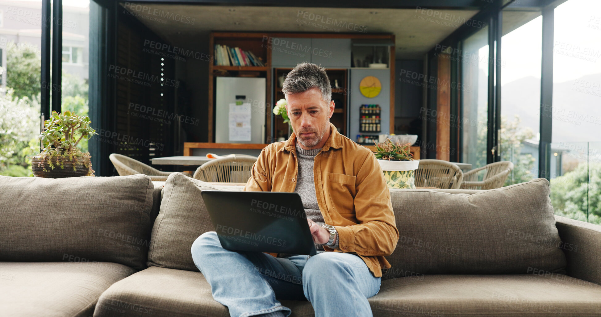Buy stock photo Remote work, laptop and mature man on sofa for online article, website research and proofreading. Freelancer, living room and person on computer for editing report, story review and planning in home