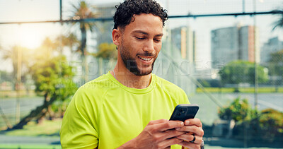 Buy stock photo Phone, fitness and man on tennis court with networking, communication or texting on mobile app. Technology, sports and athlete with typing on cellphone for chatting, contact or social media outdoor.
