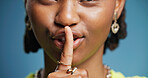 Hush, mouth and secret with black woman in studio for gossip, silence or whisper gesture. Emoji, finger on lips and quiet with African person on blue background for confidential, mystery or privacy