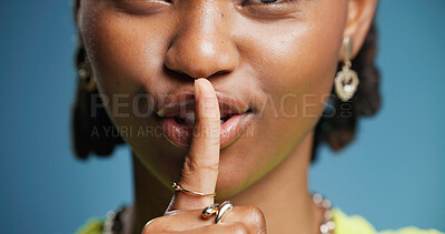 Buy stock photo Hush, mouth and secret with black woman in studio for gossip, silence or whisper gesture. Emoji, finger on lips and quiet with African person on blue background for confidential, mystery or privacy