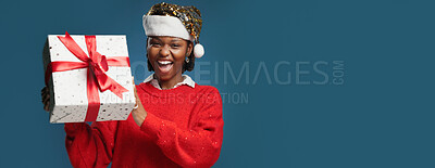 Buy stock photo Box, Christmas and portrait with black woman on studio space for celebration or surprise gift. Banner, festive and present with excited African person isolated on blue background mockup for tradition