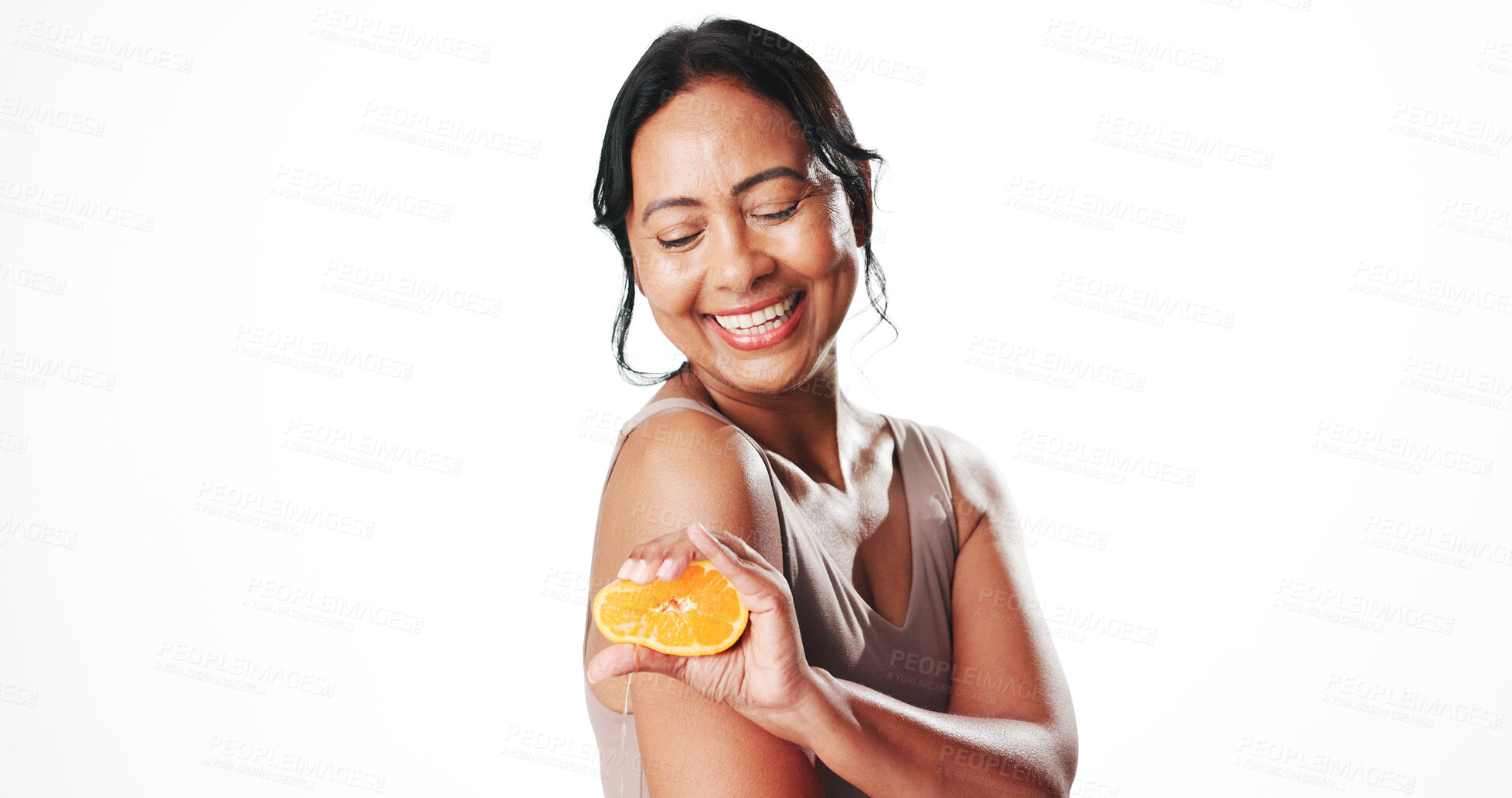 Buy stock photo Squeeze, skincare and woman with orange in studio for natural, organic or facial cosmetics. Happy, vitamin c and mature female person with citrus fruit for antiaging dermatology by white background.