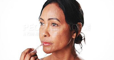 Buy stock photo Beauty, makeup and woman with lip gloss in studio for hydration, natural aesthetic and benefits. Mockup space, mature person and apply lipstick for moisturizer and SPF protection on white background