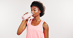 Black woman, drinking water and fitness in studio, hydration and mockup space on white background. African person, bottle and liquid for detox, wellness or gut health with break for training routine