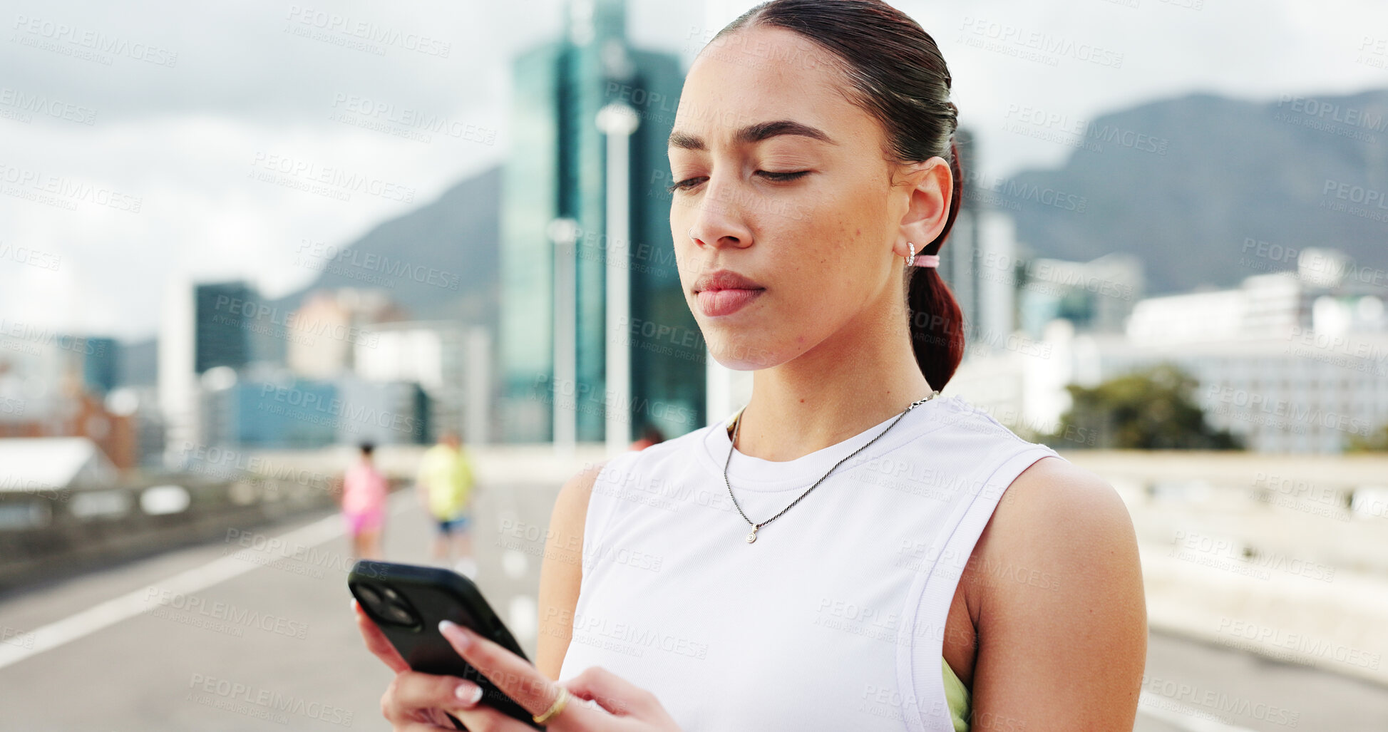 Buy stock photo Woman, runner and phone with fitness in city, bridge and break with notification, texting and training. Person, smartphone and scroll on mobile app with search for exercise tips in town with routine