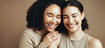 Friends, skincare and women with hug, laughing or confident with glow, beauty and cosmetics benefits. Happy, embrace and self care with dermatology, studio background and people with healthy skin