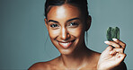 Skincare, portrait or happy woman with gua sha in studio, circulation or reduce inflammation for wellness. Dermatology beauty tool, healthy glow or person with jade crystal, space or green background