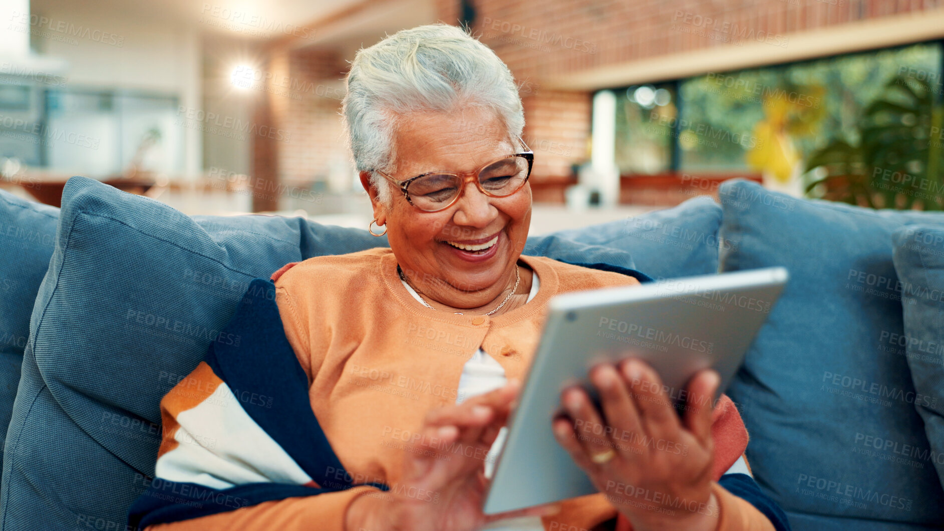 Buy stock photo Tablet, relax and senior woman on sofa in home with networking, social media or blog post. Happy, digital technology and elderly female person in living room for reading news headline in house.