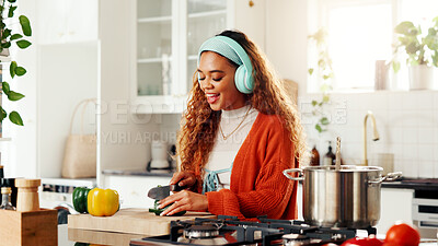 Buy stock photo Chop, cooking and headphones with woman in kitchen of home for diet or healthy food preparation. Knife, vegetables and wooden board with person streaming music in apartment for organic cuisine