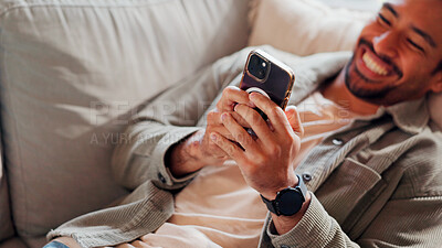 Buy stock photo Hands, smartphone and man relax in home for online dating, social media profile or post. Mobile, smile and person in living room for communication with contact, typing text or  internet with top view