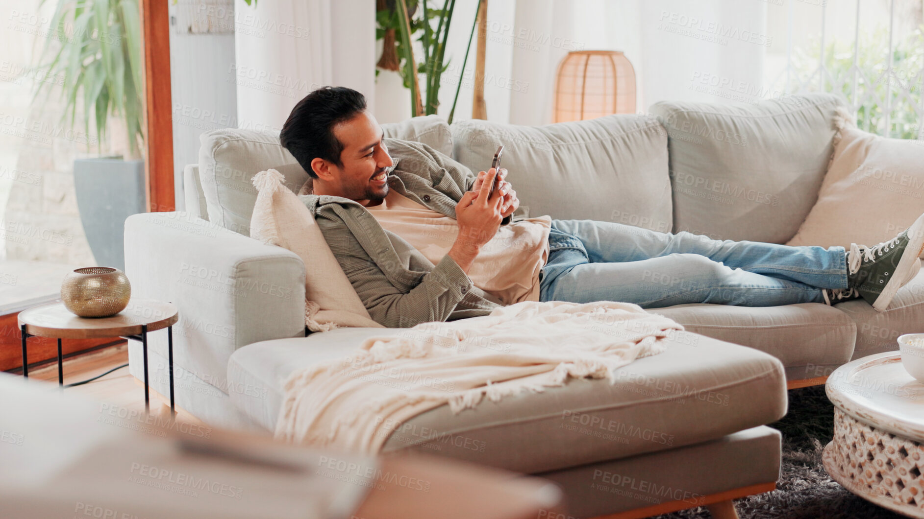 Buy stock photo Smile, cellphone and man relax on sofa for online dating, social media profile and post. Mobile, reading and happy person in home for communication with contact, typing text and response on internet