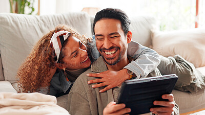 Buy stock photo Smile, interracial couple and relax with tablet at house for social media, reading meme or funny video. People, laugh and digital for streaming comedy, online joke and weekend entertainment in lounge
