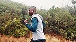 Fitness, man and running with earphones outdoor for exercise, music playlist and cardio podcast. Athlete, black person and workout in nature with audio streaming, pace training or endurance challenge