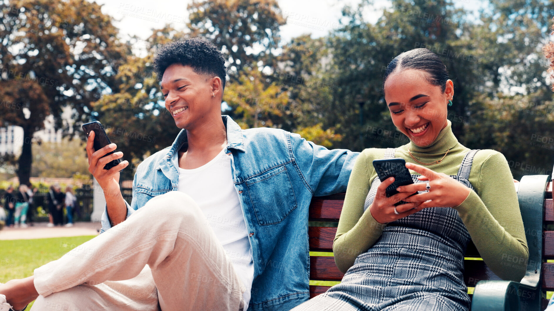 Buy stock photo Mobile, students and friends on park bench for social media, connectivity or learning at university. Phone, man and happy woman at college campus for education app, networking online or text message