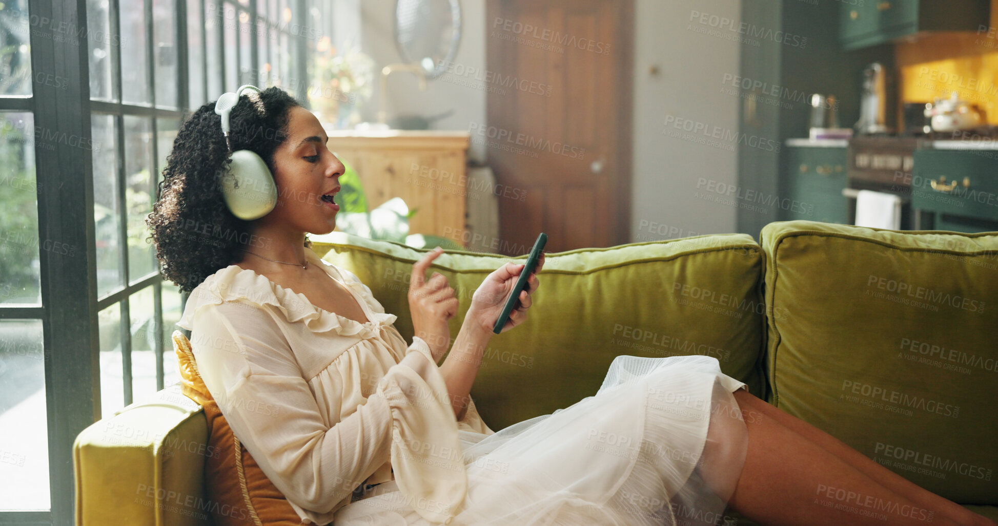 Buy stock photo Headphones, tablet and woman singing on sofa in home with listening to music, radio or song on app. Digital technology, karaoke and female person streaming playlist, podcast or album in living room.