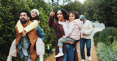 Buy stock photo Family, children and walk at park, happy and piggy back with point for sightseeing, holiday and bonding. People, parents and grandparents with kids, vacation or outdoor together at urban garden