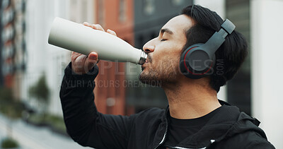 Buy stock photo Fitness, athlete and man drinking water in city for running, exercise or endurance training. Sports, hydration and male runner with liquid for cardio, sport or workout in town with headphones