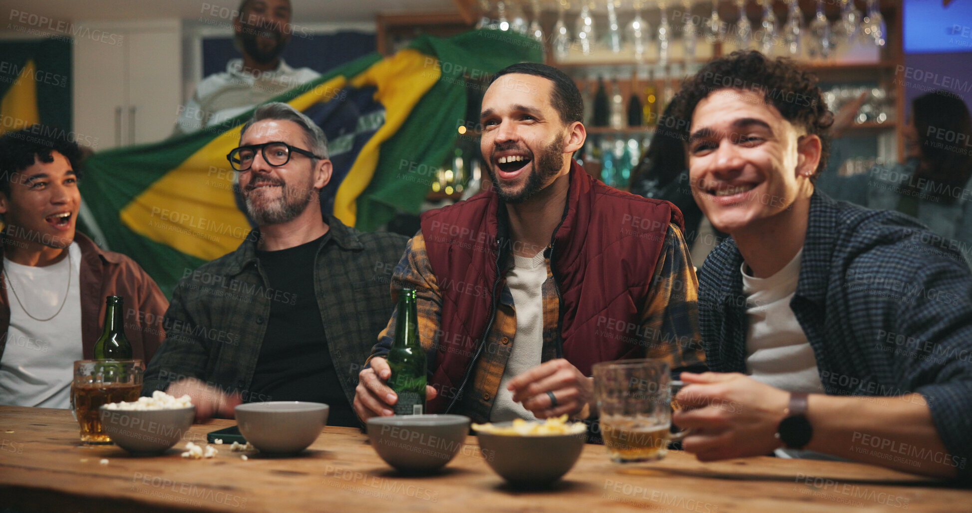 Buy stock photo Friends, excited and watching tv with drinks at sports bar, football competition or match with Brazil flag. Happy people, group and bonding with soccer game, live stream or broadcast with beer at pub