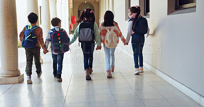 Buy stock photo Children, holding hands and group with back at school with care, connection and support in hallway. Kids, friends and together with bonding, education and development with scholarship at academy