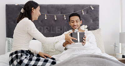 Buy stock photo Christmas, giving or couple in bed with gift, romantic moment or gratitude in xmas morning. Festive, love or people in house with present, healthy relationship or appreciation in holiday tradition