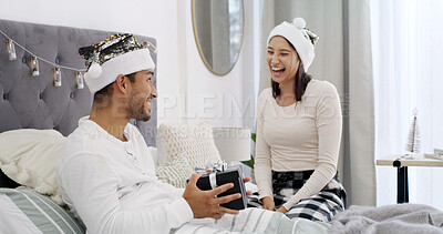 Buy stock photo Christmas, love or couple in bedroom with gift, romantic moment or gratitude in xmas morning. Festive, happy or people in house with present, healthy relationship or appreciation in holiday tradition