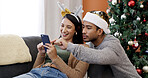 Smile, couple and phone at house on Christmas for social media, gift search and browsing website. Happy, people and mobile for festive online shopping, present decision and ecommerce deals on xmas